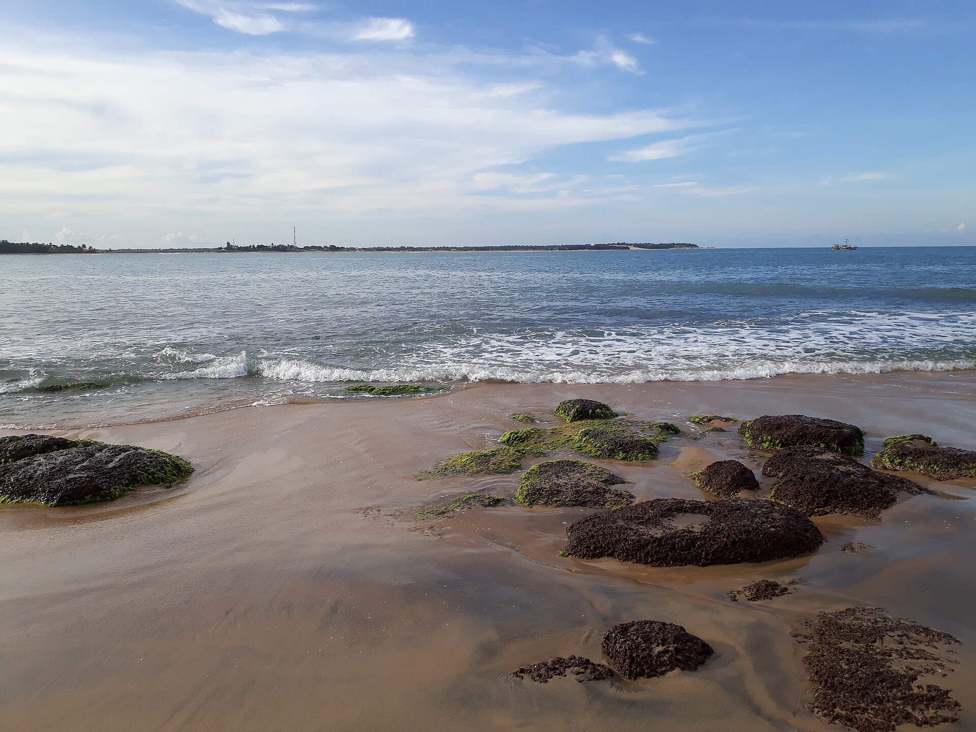 The wide sandy sweep of Arugam Bay beach on Sri Lanka's east coast.
